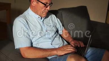 一个成熟的男人正在和一个坐在沙发上的努特贝克一起工作。 为养恤金领取人提供远程就业和网上<strong>银行服务</strong>