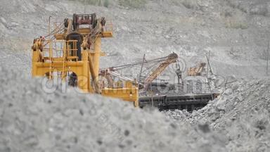 挖掘机在采石场铁路车内移动<strong>矿石</strong>.. 重型设备。