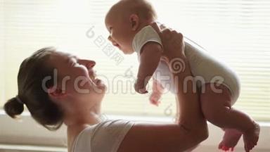 年轻的母亲抱着她新生的孩子。 妈妈在照顾宝宝。 女人和新出生的男孩在卧室里放松。 母亲母乳喂养