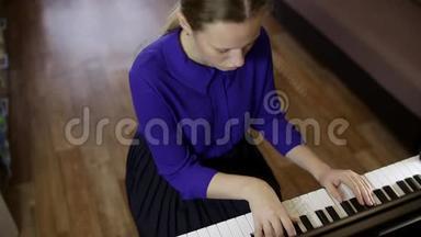 少女在数字<strong>钢琴</strong>的键盘上弹奏..