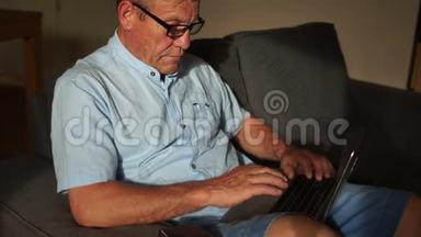 一位老人用互联网和笔记本电脑从家里支付账单。 网上银行、网上银行