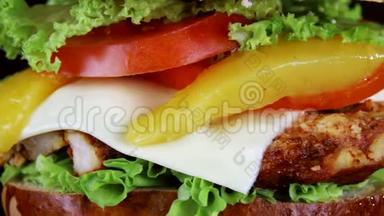 汉堡里有一大块肉、青菜和奶酪，正在黑色背景的木板上旋转