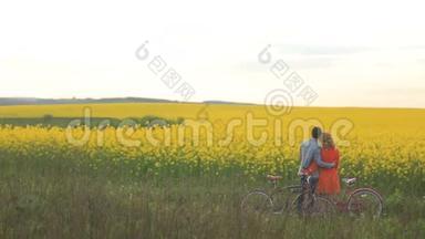 可爱的情侣们骑着自行车，<strong>轻轻地</strong>拥抱着，享受着这片美丽的田野