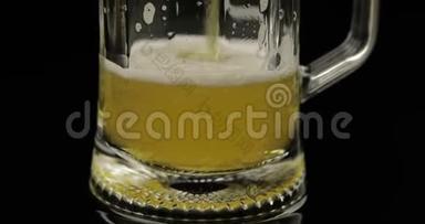 将冰冷的金光啤酒倒入玻璃杯中.. 手工啤酒制造气泡和泡沫