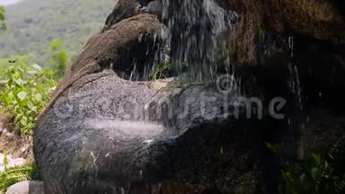 瀑布上的水流紧贴着石头. 从岩石中溅出的缓慢水流