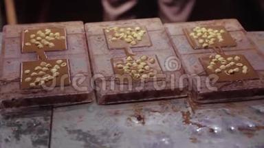巧克力工厂，制作巧克力的过程.. 将液体巧克力倒入表格中，加入坚果并冷却