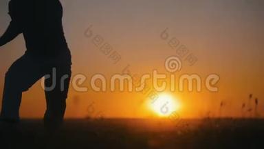 运动员在橙色日落的背景下从事capoeira，动作缓慢