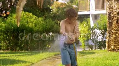 男孩在草坪上浇水，然后弄湿了