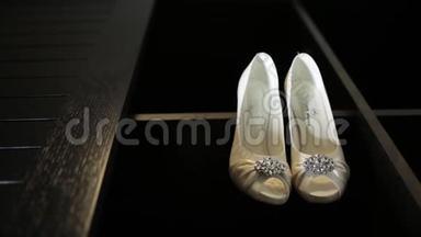 新娘婚礼漂亮的鞋子挂在一个黑色的<strong>柜子</strong>上，豪华的鞋跟特写