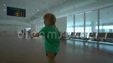 一个小男孩手里拿着白色玩具飞机，在机场里<strong>奔跑</strong>的慢镜头。 <strong>自由</strong>概念