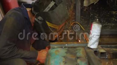 戴口罩的工人使用焊机