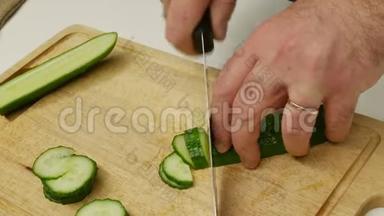 一个人切黄瓜做沙拉。 厨师是切片黄瓜。