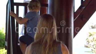 年轻女子和她的儿子走在伍登的<strong>楼</strong>梯上，来到了Phu上的一座波德寺里的<strong>二楼</strong>