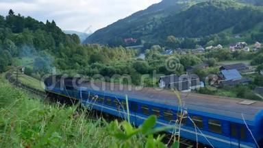 一列蓝色<strong>火车</strong>在喀尔巴阡山脉<strong>经过</strong>村庄。 夏季