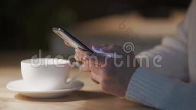 在舒适的咖啡屋里，年轻女士在智能手机上滚动，滑动页面