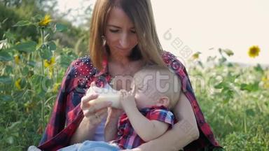 快乐妈妈在户外给婴儿<strong>奶瓶</strong>喂奶。