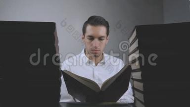 穿白衬衫的年轻人在图书馆看书。 商人在书页上滚动. 很多关于