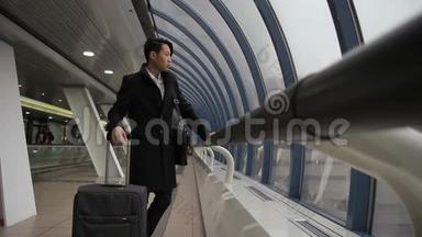 韩国亚洲人看着窗外，然后沿着机场大楼走。