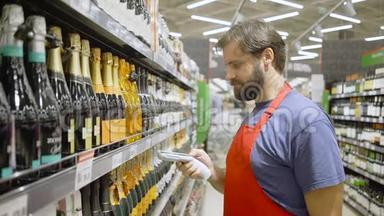 超市员工在超市的葡萄酒区用红色扫描条码