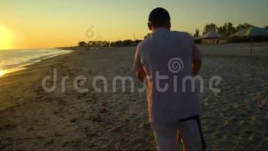 日落时，一个年轻英俊的男人和他的小女儿沿着海滨散步。 爸爸把女儿抱在怀里