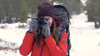 快乐的游客带着照片相机在森林里边下雪边拍照。