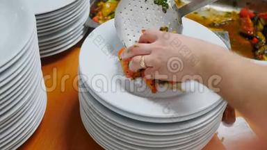 在盘子上加一份沙拉。 餐厅的厨房.. <strong>带手套</strong>的厨师的手。 顶部视图