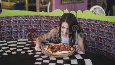微笑的女孩在咖啡馆里旋转着，欣赏着披萨的展示。 4K