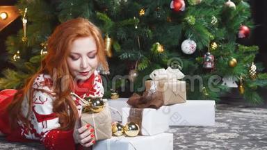 漂亮的红发女孩穿着红色毛衣躺在地上，带着礼品盒。