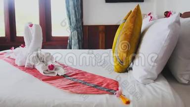 美丽的天鹅由白色毛巾制成，在Koh Phangan岛酒店有一张铺好的床。 慢动作。 3840x2160
