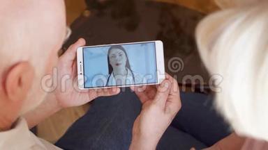 老人夫妇在家中通过信使应用程序与医生进行视频聊天咨询