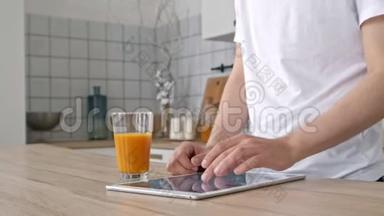 科技、家庭、饮料和生活方式的概念-用平板电脑和一杯橙汁在家中接近男人