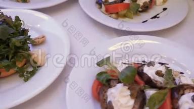 不同的沙拉，肉制品，奶酪在盘子上的白色盘子在餐厅。 旋转摄像机