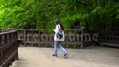少女在木桥上用手机.. 年轻人在智能手机上发短信。 <strong>运动摄像机</strong>