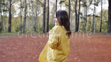 一个穿着黄色毛衣的年轻女子在秋天公园散步。 黑发女人在寒冷的森林里晒太阳。 恋爱中的女人