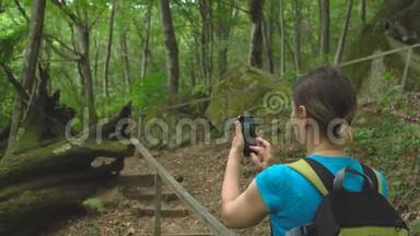 徒步旅行美女与背包<strong>制作</strong>照片智能<strong>手机</strong>丛林野生自然公园在山区。 旅游旅游