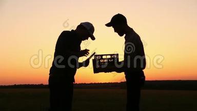 两个农民在日落时交谈。 在日落的时候。 侧视图