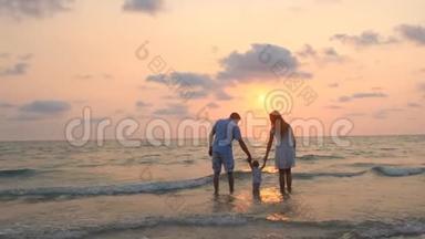 幸福的<strong>一家人</strong>在日落时沿着<strong>海边</strong>散步。