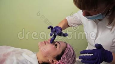 美容师在女人的脸上涂了一层舒缓霜。中胚层治疗后<strong>皮肤发红</strong>、发炎。特写