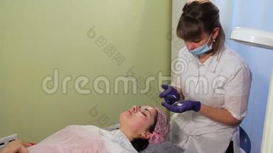 美容师在女人的脸上涂了一层舒缓霜。中胚层治疗后<strong>皮肤发红</strong>、发炎。辉光