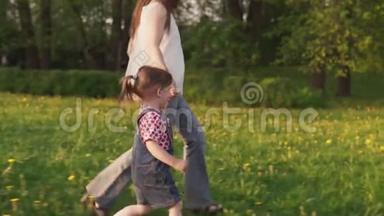 妈妈和小女儿牵着手一起在草地上奔跑