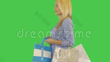 快乐的年轻女人购物狂带着购物袋散步。 侧视图。 阿尔法<strong>通道透明</strong>背景..