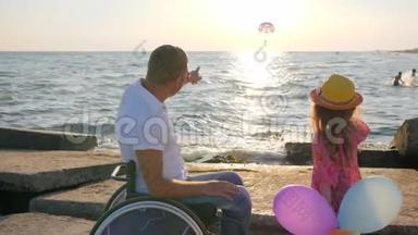 父亲坐轮椅，孩子在海边，孩子手里拿着多色气球