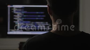 在黑暗的房间里，从后面编程并在电脑显示器上编程代码