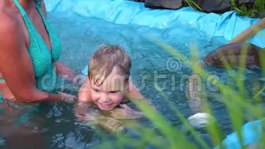 在炎热的夏天，一家人在一个小湖里游泳。 奶奶学游小孩子.. 花园、花草