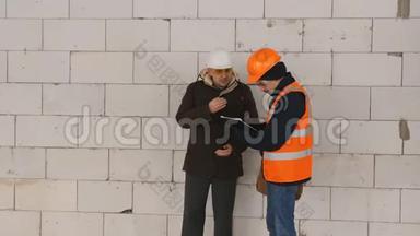 工程师和工长在施工现场冬季，讨论文件到施工现场。