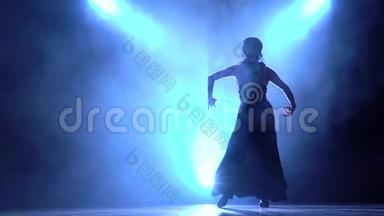 <strong>舞蹈</strong>演员穿着别致的裙子，跳着弗拉门戈的燃烧舞。 从后面发光。 <strong>烟</strong>雾背景。 剪影。 慢慢