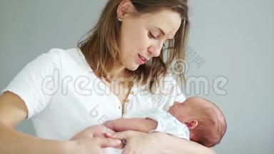 幸福妈妈抱着新生婴儿抱在怀里的特写镜头。 母亲和孩子快乐，熟睡的孩子