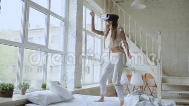 快乐的<strong>微笑</strong>年轻女子跳舞，同时体验使用360VR耳机眼镜<strong>虚拟现实</strong>在床上。