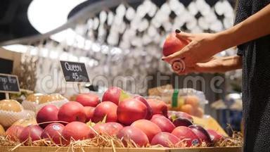 年轻的混血女人在杂货店超市挑选有机红苹果水果。 4K.