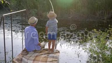 小男孩和他的父亲在湖边钓鱼，度假时家庭娱乐